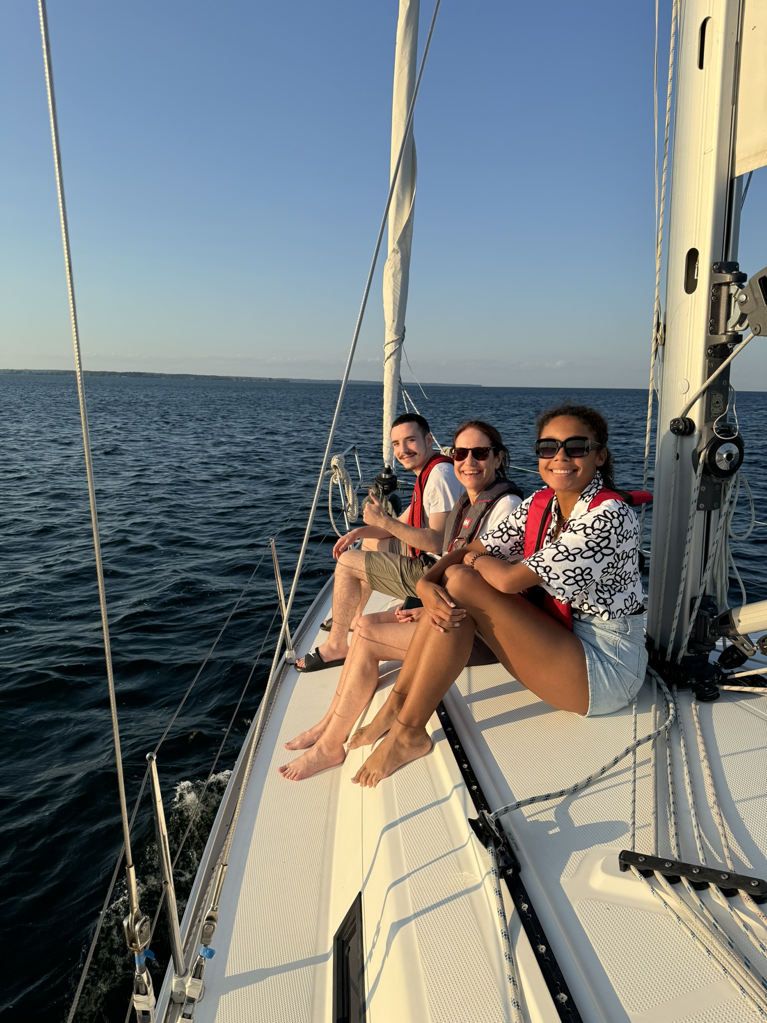 Friends relaxing on the foredeck in golden hour light